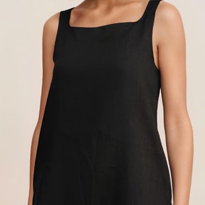 Pu&ograve; includere: Un abito nero senza maniche corto con scollo quadrato. L'abito &egrave; realizzato in un tessuto leggero e ha una vestibilit&agrave; rilassata.