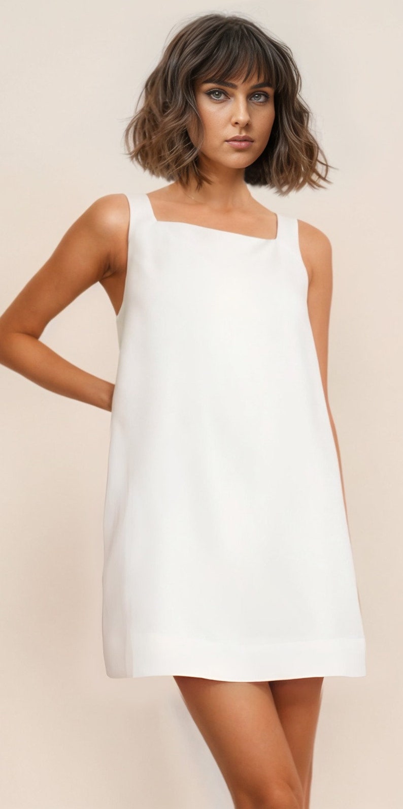 Pu&ograve; includere: Un abito bianco senza maniche con scollo quadrato. L'abito &egrave; realizzato in un tessuto leggero e ha una vestibilit&agrave; rilassata.