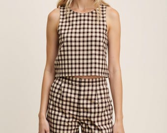 May include: A brown and cream gingham sleeveless top and matching shorts set. The top is cropped and the shorts have pleats.