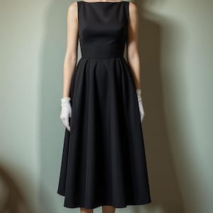 Pu&ograve; includere: Un abito midi nero senza maniche con scollo a barca e gonna ampia. L'abito &egrave; aderente in vita e ha un design semplice ed elegante.