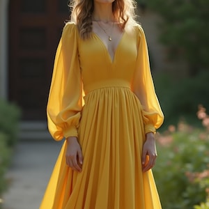 May include: A long, flowing yellow dress with a deep V-neck and long, sheer sleeves. The dress has a fitted waist and a full skirt. A gold necklace is visible. The dress is suitable for formal events.