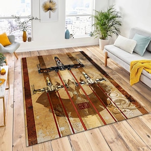 May include: A rectangular area rug featuring a design of three X-wing starfighters in flight, with red contrails against a tan and brown striped background. The rug has a distressed, vintage aesthetic, with a Japanese-style emblem.