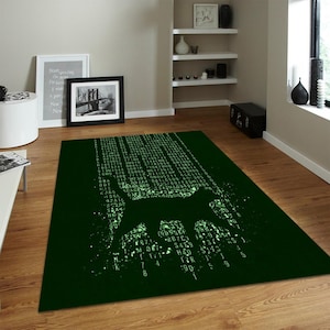 Peut inclure: Un tapis rectangulaire au fond vert foncé avec un motif central représentant la silhouette d'un chat formée par des codes numériques, des chiffres et des symboles vert clair lumineux, créant un effet visuel inspiré de la matrice.