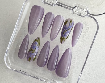 Uñas postizas de ojo de gato con flores moradas pintadas a mano