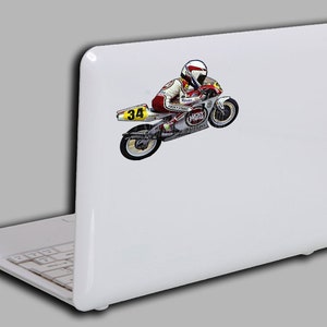 Puede incluir: Un portátil blanco con una pegatina de un piloto de moto en la parte posterior. El piloto lleva un casco rojo, blanco y azul y un traje de carreras rojo, blanco y azul. La moto es roja, blanca y negra. La pegatina tiene el número 34.