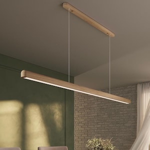 May include: A modern, rectangular wooden pendant light fixture with a bright, linear LED light source. The fixture is suspended from the ceiling by thin, white cords. The light is mounted above a wooden table, suggesting a dining room setting.