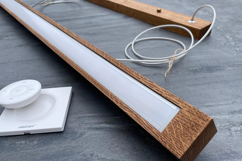 May include: A wooden LED light fixture with a white light strip, a white remote control, and a white base with the text "HIBOXER". The fixture has a natural wood grain finish and a white power cord.
