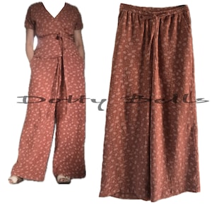 Pode incluir: Uma cal&ccedil;a de perna larga com estampa floral em cor ferrugem. A cal&ccedil;a tem cintura el&aacute;stica com cord&atilde;o.