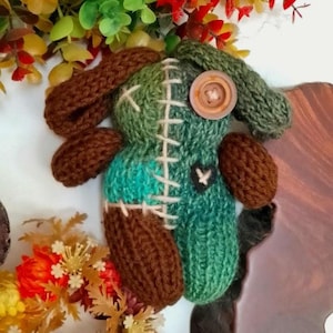 May include: A white ceramic mug with a black handle and the text "But First, Coffee" in a bold, black font. The mug is set against a blurred background, suggesting a cozy setting.