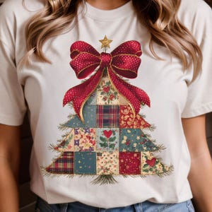 Könnte beinhalten: Cremefarbenes T-Shirt mit einem Weihnachtsbaum-Design. Der Baum besteht aus Patchwork-Quadraten in verschiedenen Mustern und Farben, gekrönt von einer roten Schleife und einem goldenen Stern. Die Schleife hat ein Tupfenmuster.