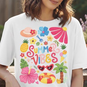 Op de afbeelding: Wit T-shirt met een kleurrijk "Summer Vibes" ontwerp. Het ontwerp bevat een ananas, bloemen, zonnebrillen, een strandhoed en een ijsje. Een casual zomerstijl.