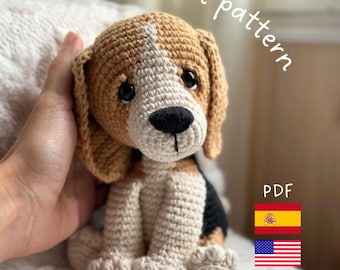 Puede incluir: Patrón de crochet PDF para un amigurumi de perro Beagle. El patrón está disponible en español e inglés. El amigurumi es marrón, blanco y negro.