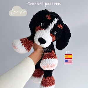 Puede incluir: Un peluche de perro hecho a mano con ganchillo en negro, blanco y marrón. El peluche tiene un hocico, patas y una raya en la cara blancos. El texto "Crochet pattern" y "Low sew" son visibles. También es visible el nombre de la tienda "Amapolas BABY SHOP".