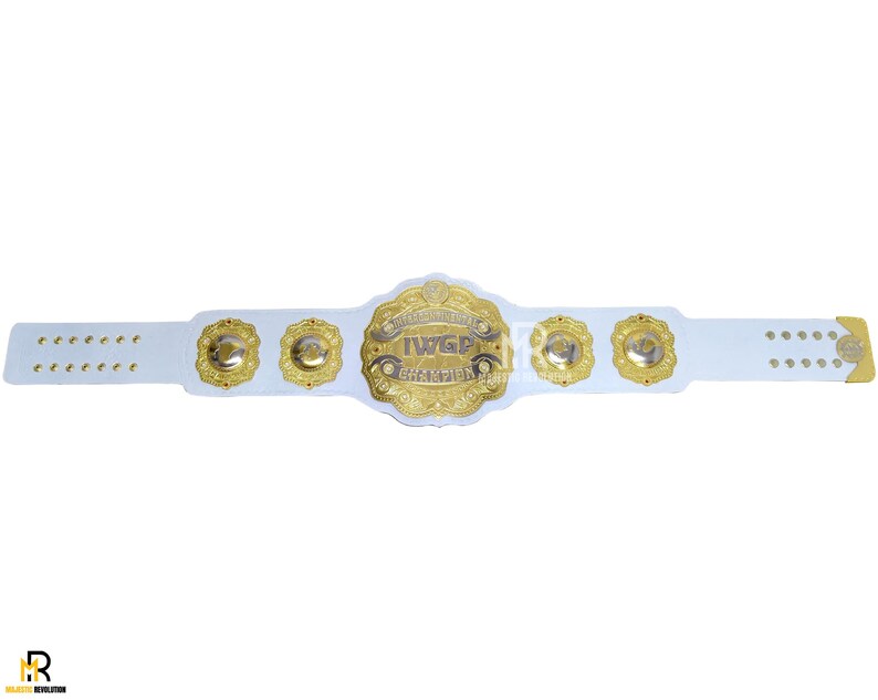 May include: A white wrestling championship belt with gold accents. The center plate features the text "IWGP CHAMPION" in gold lettering. The belt has several gold medallions and a white strap with multiple holes for adjustment.