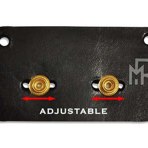 May include: Black leather adjustable strap with two gold metal buckles and the text "ADJUSTABLE" and the initials "MR" in white.
