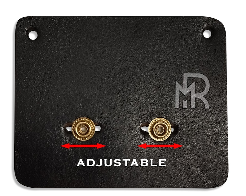 May include: Black leather strap with two adjustable brass buckles. The strap has the letters "MR" embossed in the center.