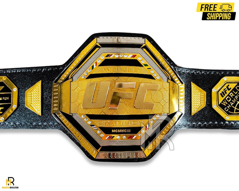 May include: A gold and black UFC championship belt with a hexagonal center plate featuring the UFC logo and the words "World Champion" and "MCMXCIII".
