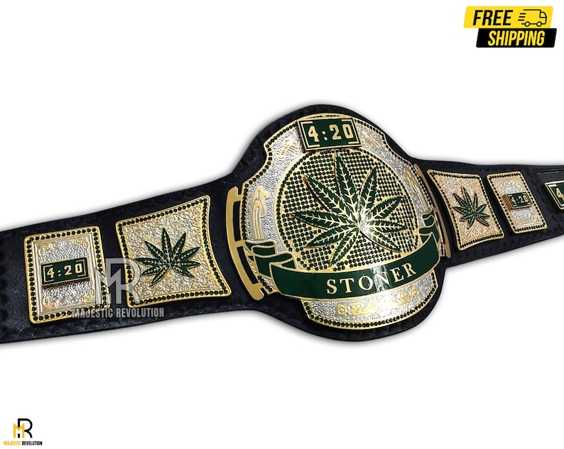 Pode incluir: Um cintur&atilde;o de campeonato preto e dourado com um design de folha de maconha verde. O cinto apresenta as palavras "4:20" e "STONER" na frente.