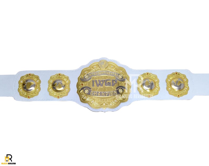 May include: A white wrestling championship belt with gold accents. The belt features a large central gold emblem with the text "IWGP Intercontinental Champion" and four smaller gold emblems.