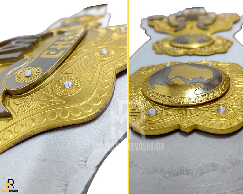 May include: Close-up of a gold and silver championship belt with intricate detailing. The belt features the word "CHAMP" and a globe design, with clear gemstones. The design is set against a white background.