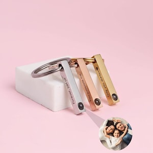 May include: A set of four metal keychains in silver, rose gold, and gold. Each rectangular charm is engraved with a different phrase: "Forever, just us", "You complete me", and "Only you always". A small photo is included.