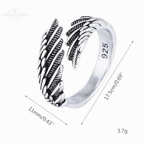 May include: A silver-colored ring with a wing design. The ring is open, with the wing extending around the finger. The ring is 0.69 inches wide and weighs 3.7 grams. The ring is marked with "925".