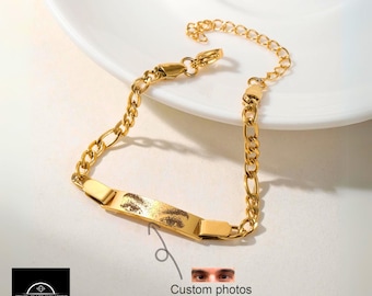 May include: Gold chain bracelet with a rectangular tag that can be personalized with a photo. The tag has a photo of a person's eyes.  Custom photos.