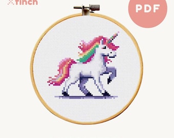 Puede incluir: Un patrón de punto de cruz con un unicornio blanco con una crin y cola arcoíris. El patrón está en un aro de bordado circular y está etiquetado como "MINI PATTERN".
