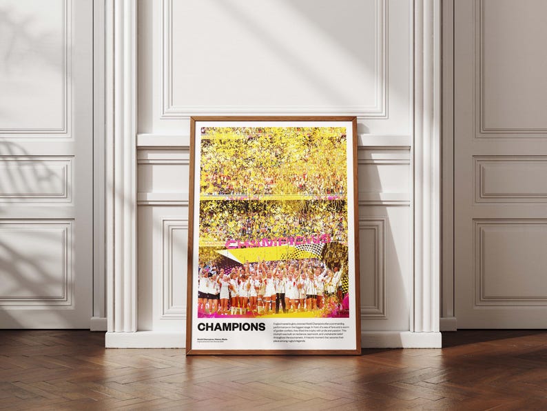 May include: A framed poster with a wooden frame, featuring a vibrant image of a sports team celebrating a victory. The word "CHAMPIONS" is prominently displayed in pink and white. The background shows a stadium filled with confetti.