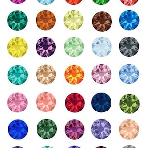 Puede incluir: Una colección de treinta y seis gemas redondas y facetadas en una variedad de colores. Las gemas incluyen tonos de rosa, rojo, azul, verde, amarillo, naranja, morado y marrón. Cada gema tiene un patrón de estrella.