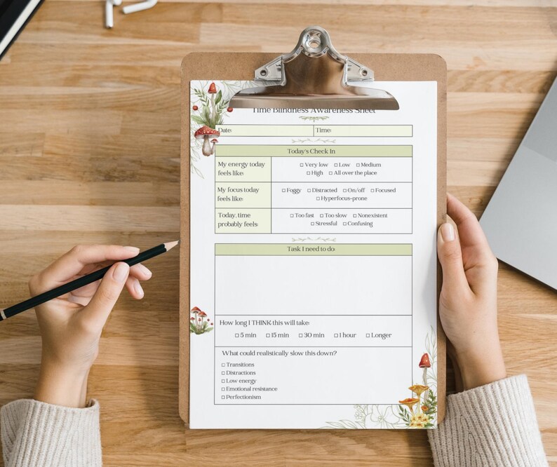 May include: A clipboard with a printed "Time Blindness Awareness Sheet" featuring a mushroom and leaf design. The sheet includes sections for daily check-ins and tasks. A hand holds a pencil, ready to write.