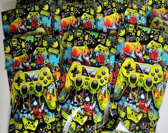 May include: A stack of colourful plastic bags featuring a graphic design of a yellow video game controller on a black background. The bags are sealed and ready to be filled with treats or small gifts.