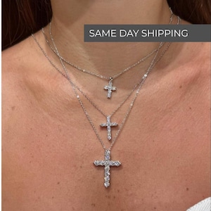 May include: Three silver necklaces with cross pendants, each with a different size cross. The crosses are encrusted with clear gemstones. The text "SAME DAY SHIPPING" is in a gray box.