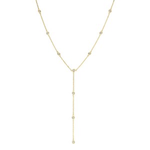 May include: A gold lariat necklace featuring a delicate chain with evenly spaced bezel-set round clear stones. The design includes a central junction point where the chain continues downward into a single vertical drop, accented with additional stones.