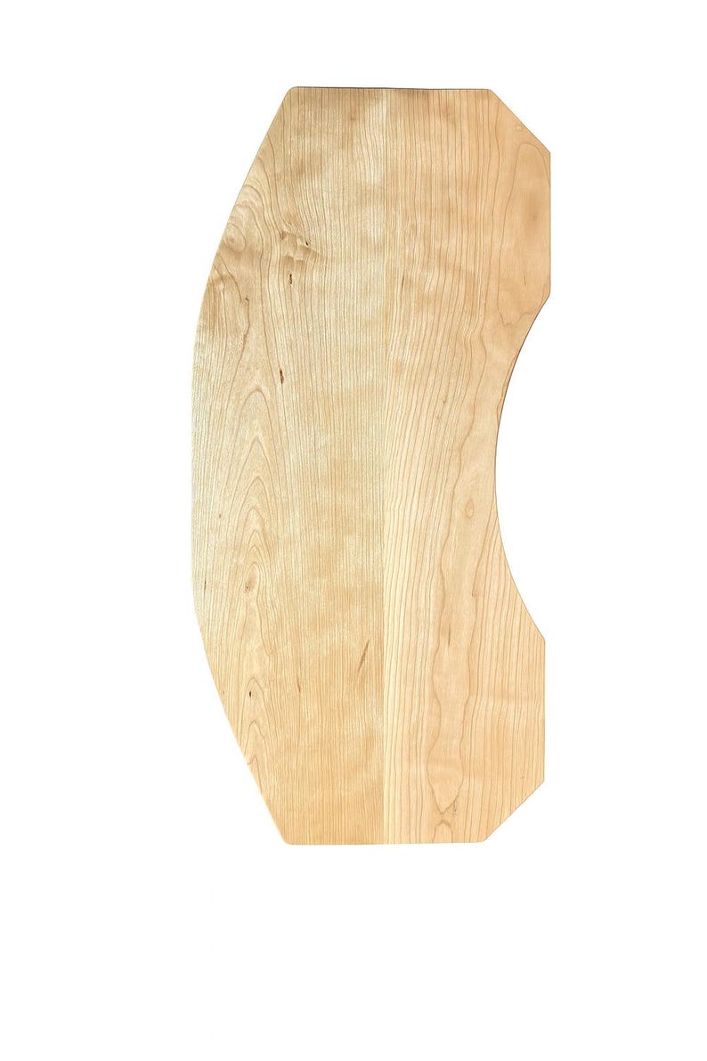 May include: A light-colored, wooden, irregularly shaped board with a curved edge. The wood grain is visible, and the board has a smooth surface. The board is likely for woodworking or crafting projects.