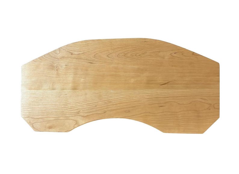 May include: A light-colored wooden desk top with a unique shape. The desk top has a curved front edge and a rectangular back. The wood grain is visible, and the color is a light tan.