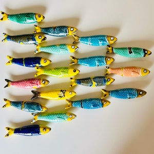Sardines in glazed ceramics from Portugal. Wall decoration with the vibrant colors of ocean fish, transporting us to a lush ecosystem.