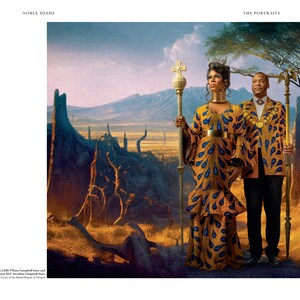 May include: A couple in regal attire stand in a desert landscape. The woman wears a yellow and blue patterned dress with a gold belt and a crown. She holds a scepter with a cross on top. The man wears a yellow and blue patterned jacket with gold accents and a gold chain. He holds a scepter with an eagle on top. The background is a desert landscape with trees and mountains in the distance.