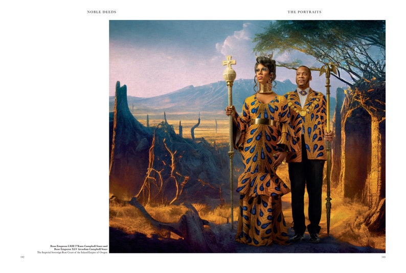 May include: A couple in regal attire stand in a desert landscape. The woman wears a yellow and blue patterned dress with a gold belt and a crown. She holds a scepter with a cross on top. The man wears a yellow and blue patterned jacket with gold accents and a gold chain. He holds a scepter with an eagle on top. The background is a desert landscape with trees and mountains in the distance.