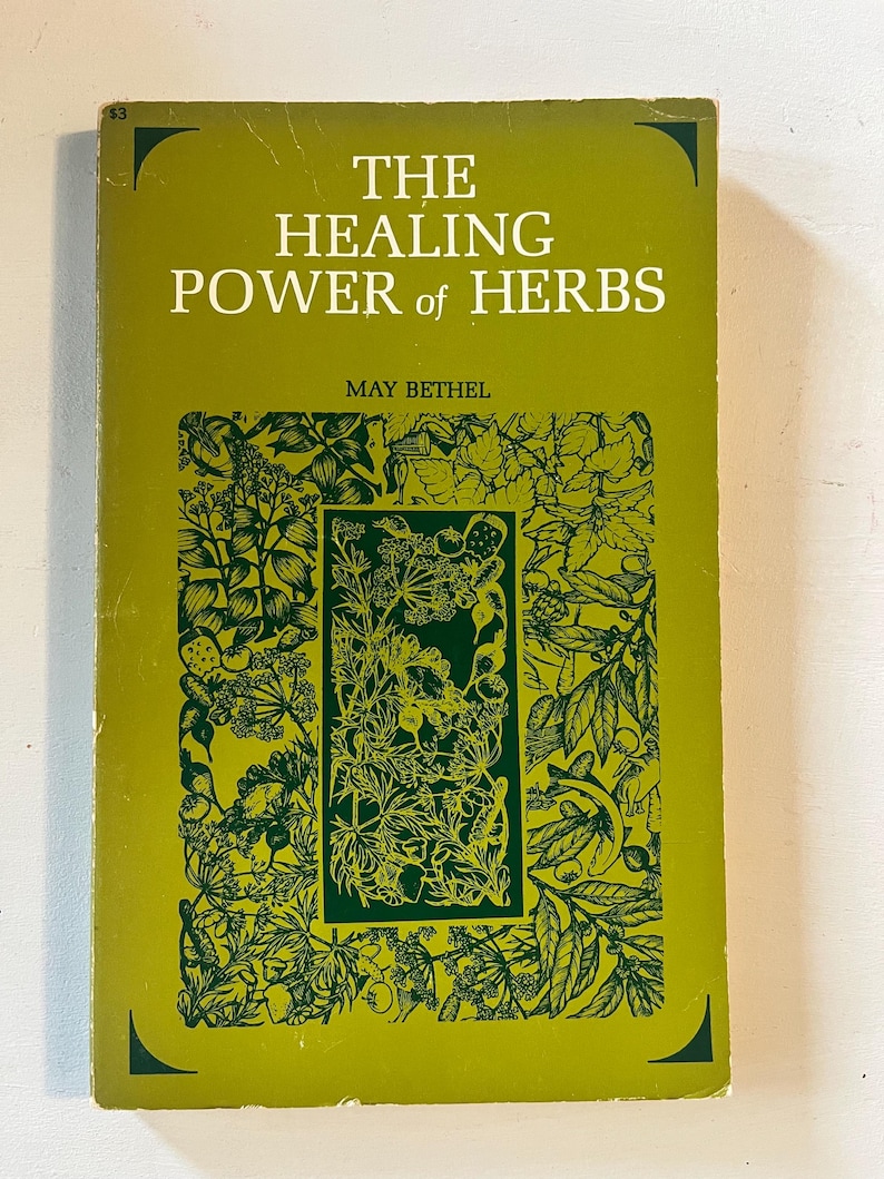 May include: A vintage book titled "The Healing Power of Herbs" by May Bethel. The cover is a light green with dark green botanical illustrations and text. The book's title is in large, bold white letters.