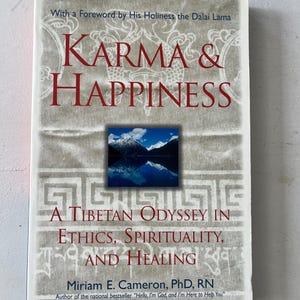 May include: A book titled "Karma & Happiness" with a foreword by the Dalai Lama. The cover features a mountain landscape and the subtitle "A Tibetan Odyssey in Ethics, Spirituality, and Healing."