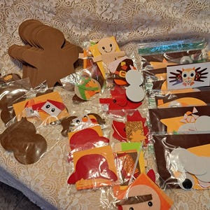 Puede incluir: Una colección de materiales de artesanía para hacer decoraciones con temática de Acción de Gracias. Los materiales incluyen piezas de fieltro en varias formas, colores y tamaños, así como ojos saltones, purpurina y otros adornos.