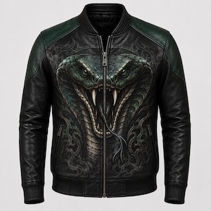 May include: A black bomber jacket featuring a large, detailed graphic of a green snake with an open mouth and visible fangs centred on the front. The jacket has a full-length front zip, ribbed cuffs and hem, and dark green shoulder panels.
