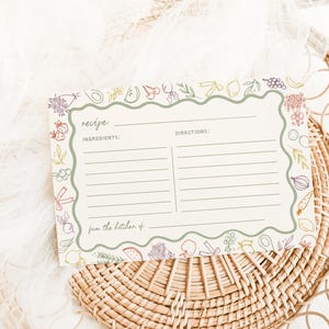 May include: A blank recipe card with a green border and a colourful illustration of fruits and vegetables. The card has the words "recipe", "ingredients", "directions", and "from the kitchen of" printed on it.