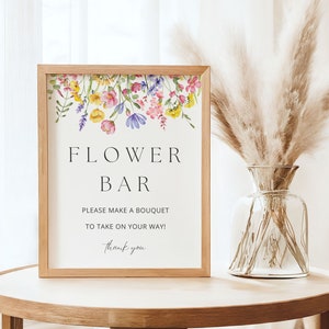 Photo shows the flower bar sign size 8x10 inch framed on a wooden table next to a vase.