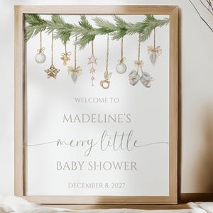 Christmas baby shower song is shown printed as the 16x20” size and placed in a frame and sitting on a table.