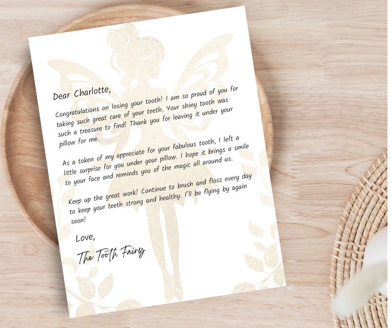 photo shows white and gold tooth fairy letter printed on 8.5x11” paper and laying flat on a table.