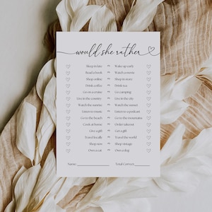 May include: A printable "Would She Rather" game with a heart design. The game features a list of 16 questions with two choices each. The choices are related to lifestyle preferences, such as sleeping in late vs. waking up early, reading a book vs. watching a movie, and shopping online vs. shopping in a store.