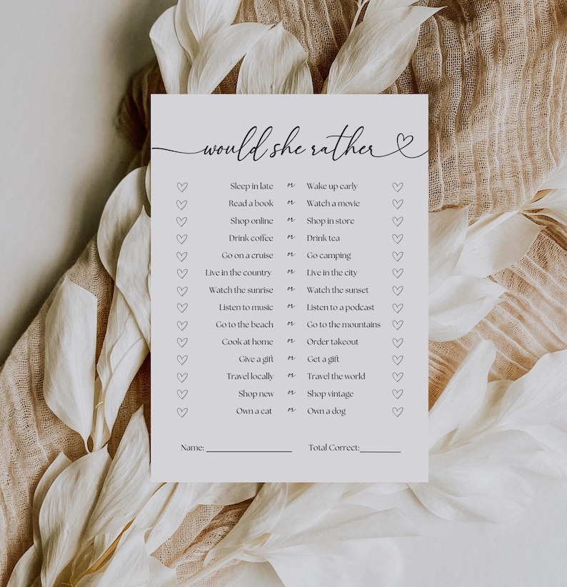 May include: A printable "Would She Rather" game with a heart design. The game features a list of 16 questions with two choices each. The choices are related to lifestyle preferences, such as sleeping in late vs. waking up early, reading a book vs. watching a movie, and shopping online vs. shopping in a store.