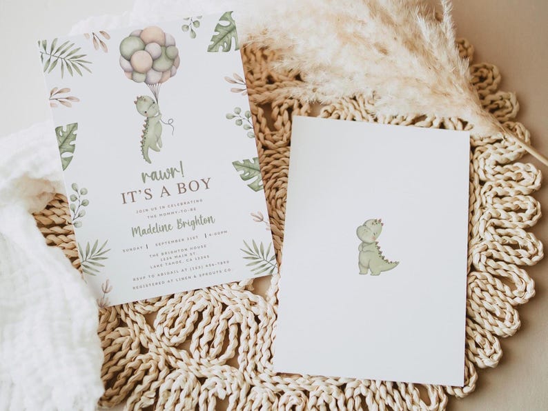 Op de afbeelding: Een witte uitnodigingskaart en een bijpassende blanco kaart met een aquarel groene dinosaurus die een tros pastelkleurige ballonnen vasthoudt. De uitnodiging bevat de tekst rawr! IT'S A BOY, JOIN US IN CELEBRATING THE MOMMY-TO-BE, Madeline Brighton, en evenementdetails.